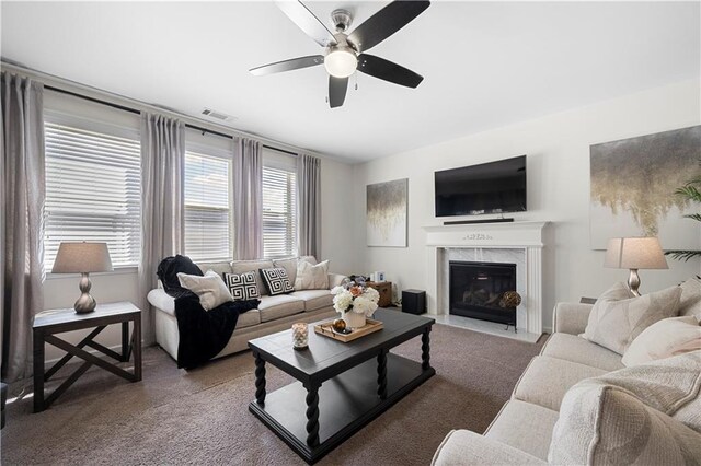 carpeted living room featuring a fireplace and ceiling fan