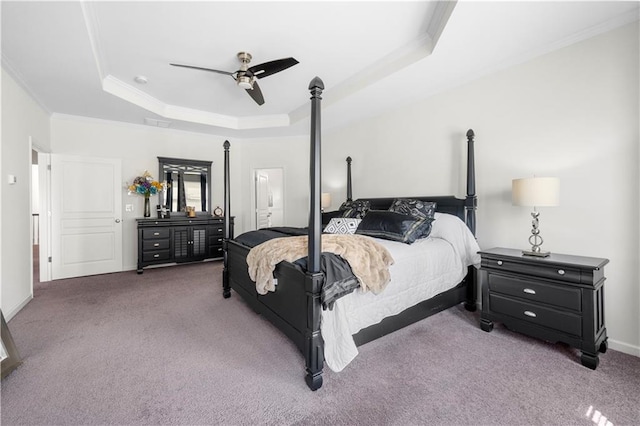 bedroom featuring a tray ceiling, ceiling fan, carpet floors, and crown molding