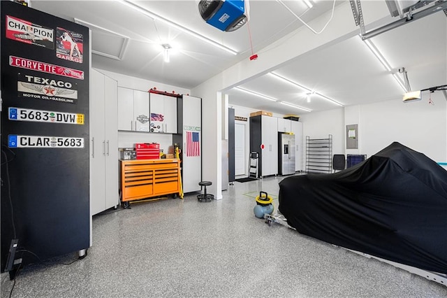 garage featuring a garage door opener, electric panel, and stainless steel fridge with ice dispenser