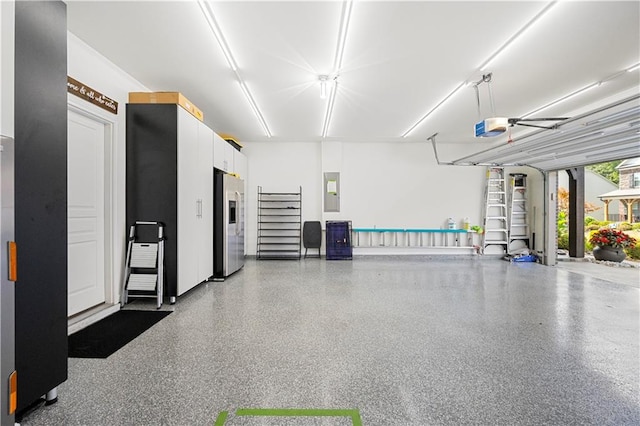 garage featuring a garage door opener, electric panel, and stainless steel fridge