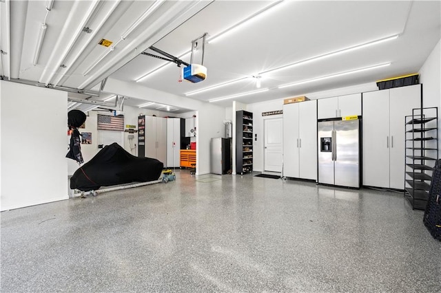 garage featuring stainless steel fridge and a garage door opener