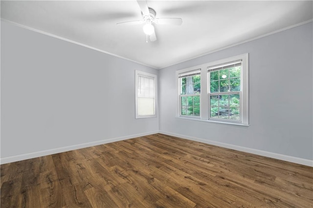 unfurnished room featuring crown molding, baseboards, and dark wood-style flooring