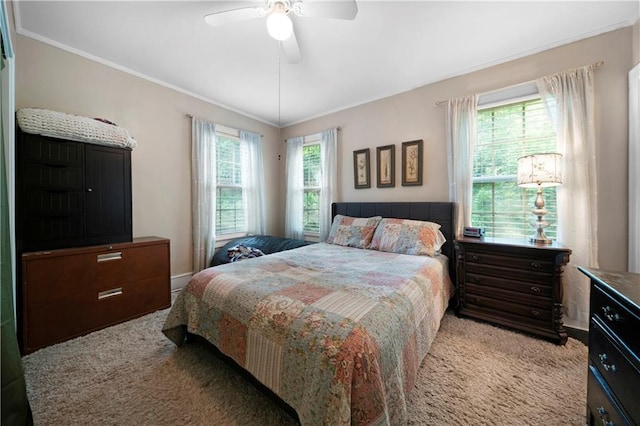carpeted bedroom with ornamental molding and ceiling fan