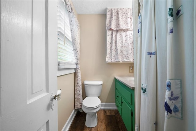 bathroom featuring baseboards, vanity, toilet, and wood finished floors