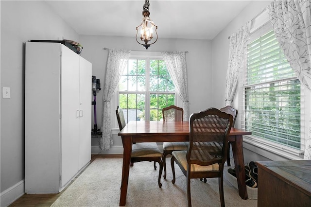 dining room featuring baseboards, light wood-style floors, and a chandelier