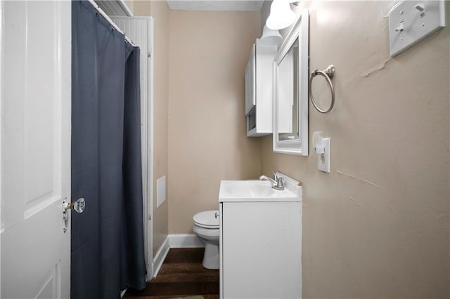 bathroom featuring vanity, a shower with shower curtain, wood finished floors, and toilet