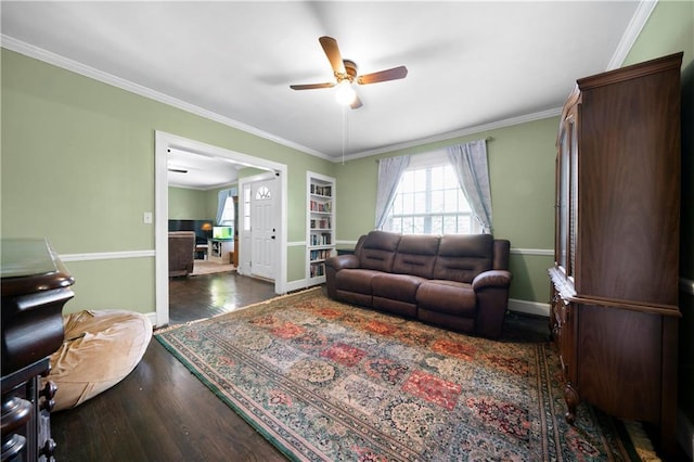 living room with crown molding, a ceiling fan, baseboards, and wood finished floors