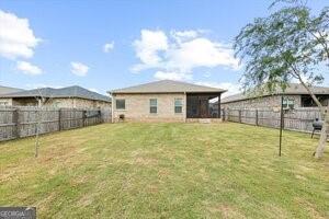 rear view of property featuring a lawn