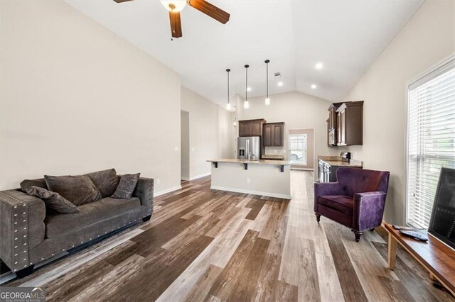 living room featuring vaulted ceiling, hardwood / wood-style flooring, and ceiling fan