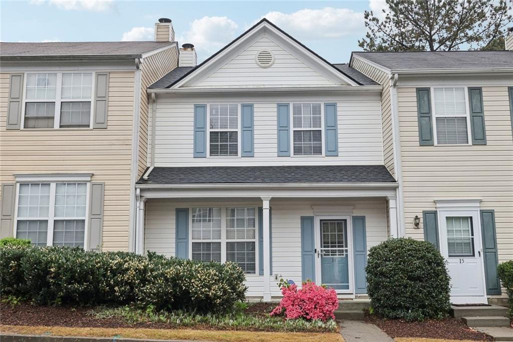 townhome / multi-family property with a shingled roof and a chimney
