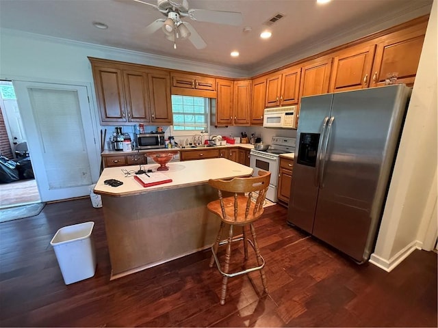 349 Bald Rock Rd, Oxford, GA 30054 - kitchen featuring appliances with stainless steel finishes, a kitchen island, dark wood-style flooring, a sink, and brown cabinetry