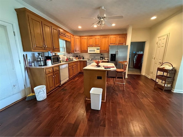 349 Bald Rock Rd, Oxford, GA 30054 - kitchen featuring stainless steel appliances, brown cabinets, a kitchen bar, dark wood-style floors, and recessed lighting