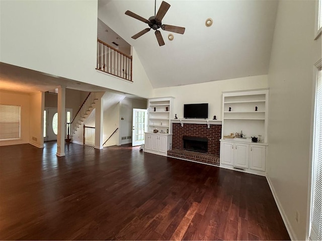 349 Bald Rock Rd, Oxford, GA 30054 - unfurnished living room with high vaulted ceiling, a ceiling fan, a brick fireplace, dark wood-type flooring, and stairs