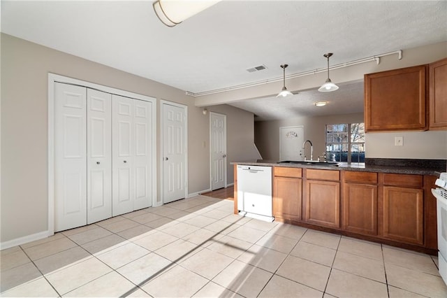 kitchen featuring hanging light fixtures, light tile patterned flooring, sink, and white appliances