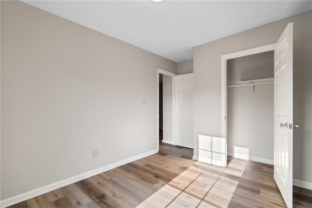 unfurnished bedroom featuring light hardwood / wood-style flooring and a closet