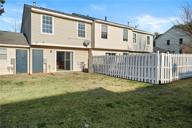 rear view of house featuring a yard and central AC