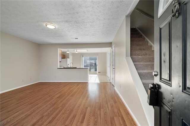 interior space featuring a textured ceiling and light wood-type flooring