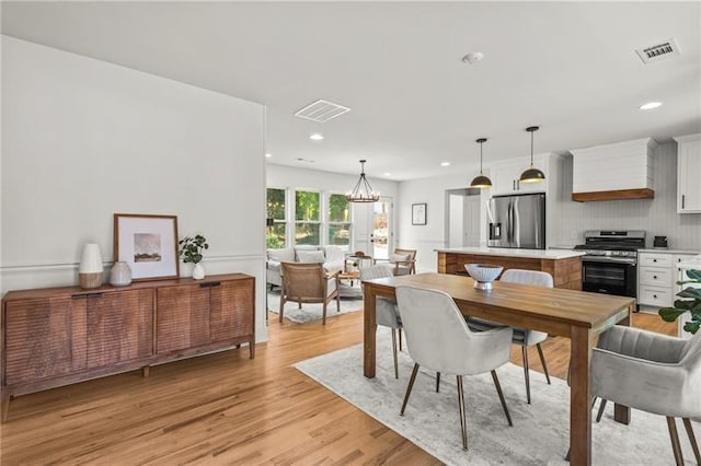 dining area with an inviting chandelier and light wood-type flooring