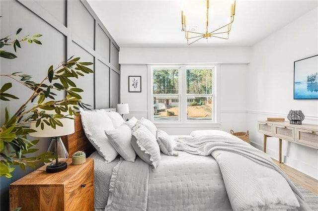 bedroom featuring hardwood / wood-style flooring and an inviting chandelier