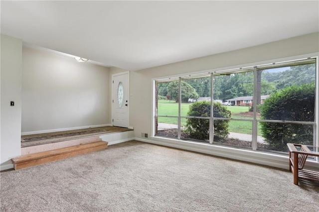 unfurnished living room featuring baseboards and carpet floors