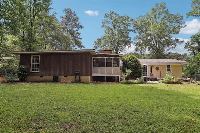 view of front of house with crawl space, a front lawn, a sunroom, and a chimney