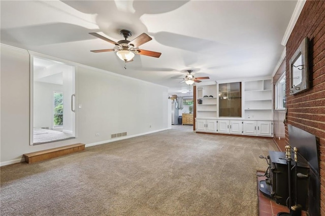 unfurnished living room with light colored carpet, a ceiling fan, baseboards, and crown molding