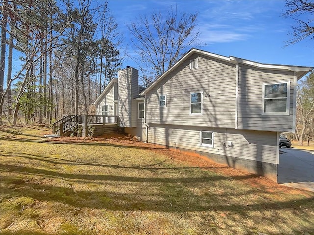 view of side of property with stairs, a chimney, and a yard