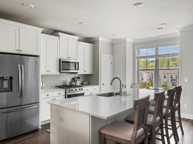 3862 Firewood Ln Unit 110, Suwanee, GA 30024 - kitchen with stainless steel appliances, ornamental molding, a sink, dark wood finished floors, and a kitchen island with sink