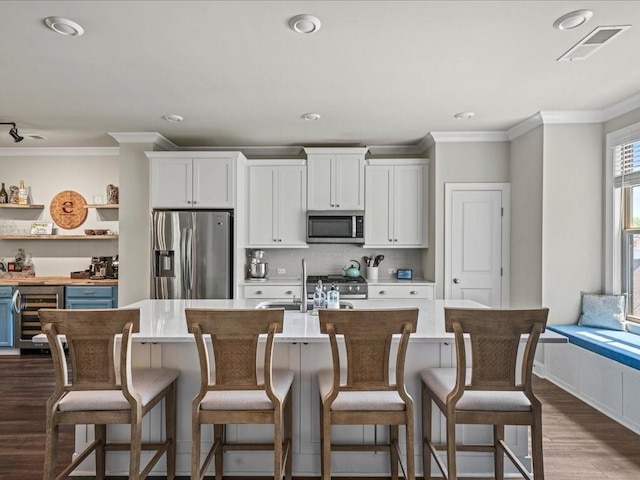 3862 Firewood Ln Unit 110, Suwanee, GA 30024 - kitchen with stainless steel appliances, wine cooler, dark wood-style flooring, white cabinetry, and ornamental molding