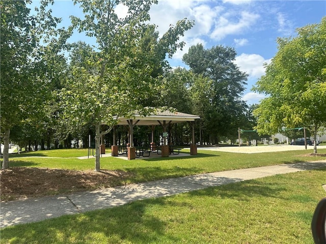 view of community with a lawn and volleyball court