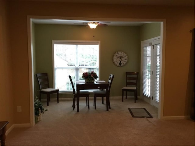 dining space featuring light carpet, a wealth of natural light, and ceiling fan