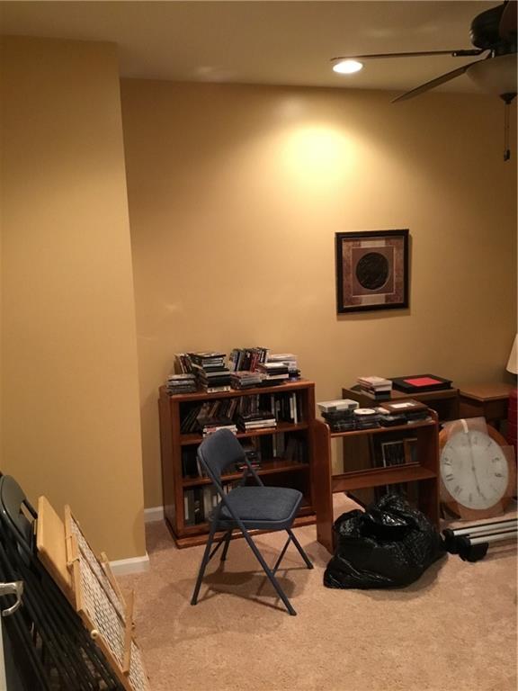 carpeted home office featuring ceiling fan