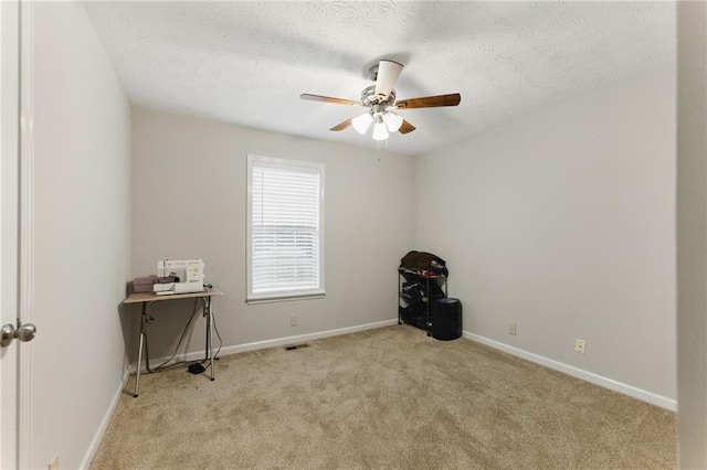 interior space featuring baseboards, carpet, a ceiling fan, and a textured ceiling