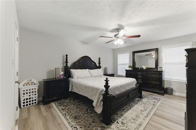 bedroom with baseboards, a textured ceiling, a ceiling fan, and light wood finished floors