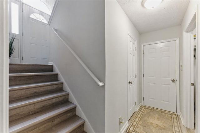 staircase with a textured ceiling