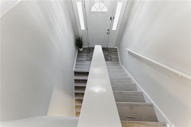 stairway featuring wood finished floors and baseboards