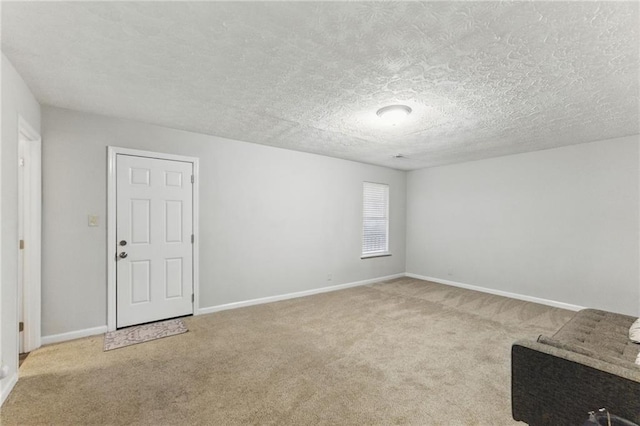 carpeted empty room featuring baseboards and a textured ceiling