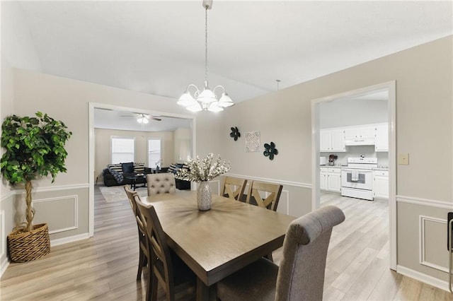 dining room featuring an inviting chandelier, light wood-style floors, and lofted ceiling