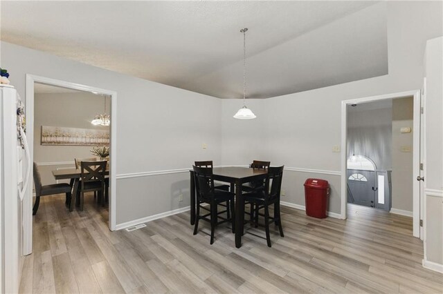 dining area featuring visible vents, light wood-type flooring, and baseboards