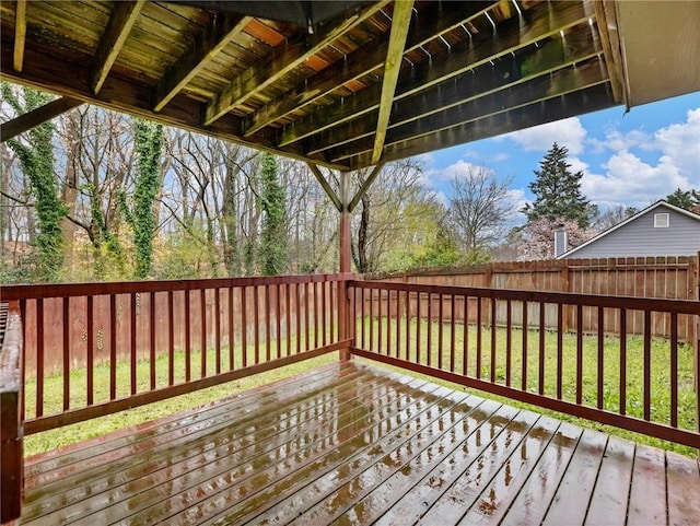 wooden terrace with a lawn and a fenced backyard