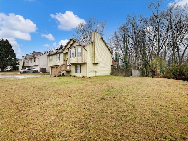 exterior space featuring a chimney, a yard, and fence