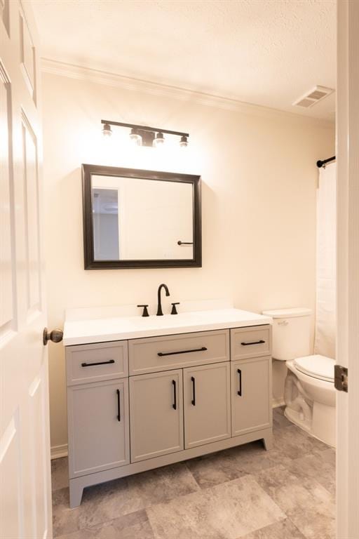 bathroom with vanity, crown molding, and toilet