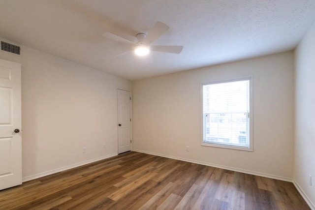 spare room featuring dark hardwood / wood-style floors and ceiling fan