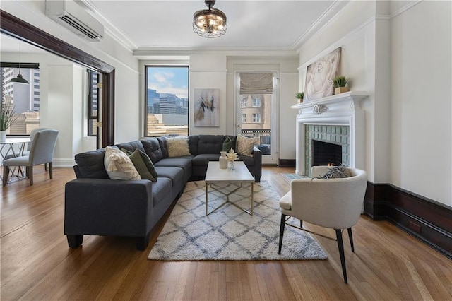75 Ponce De Leon Ave Unit 701, Atlanta, GA 30308 - living area featuring a wall mounted air conditioner, a lit fireplace, wood finished floors, ornamental molding, and a chandelier