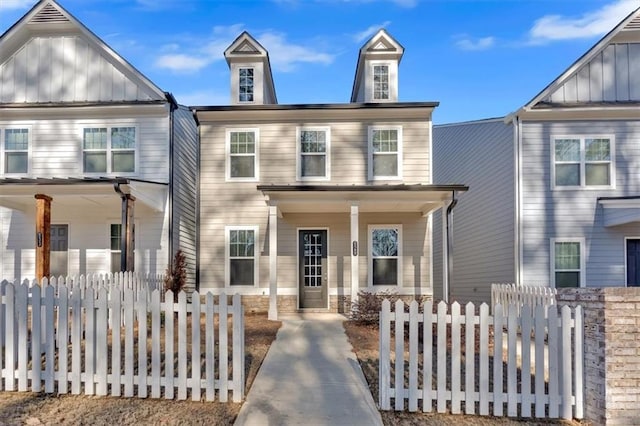 view of front of house with a porch, a fenced front yard, and board and batten siding