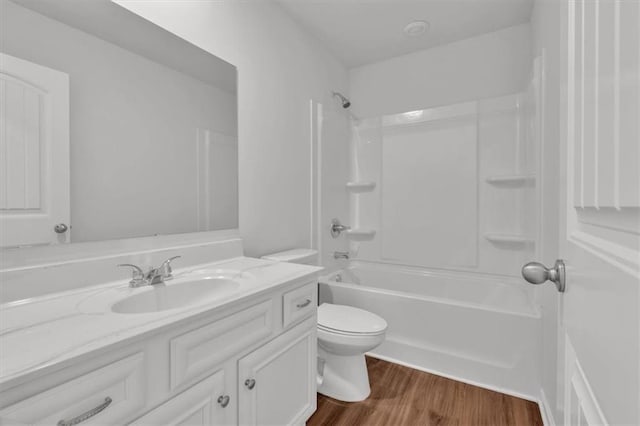 bathroom with tub / shower combination, vanity, toilet, and wood finished floors