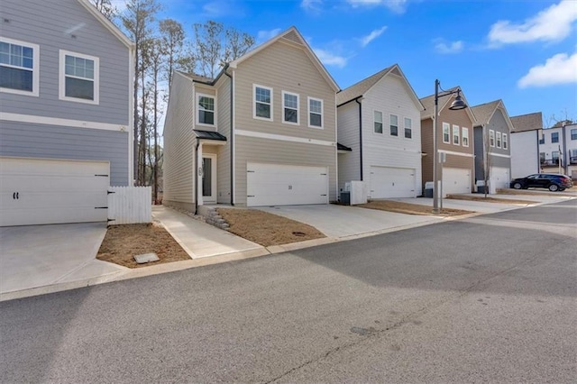 view of front of house with a garage, a residential view, and concrete driveway