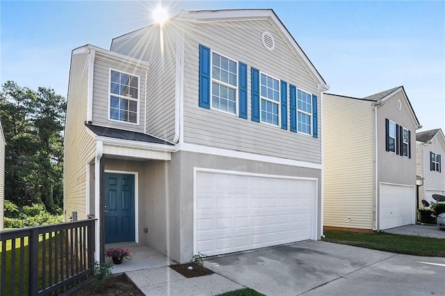 view of front of property featuring driveway, an attached garage, and stucco siding