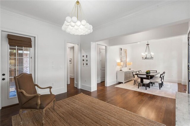 dining space featuring ornamental molding, an inviting chandelier, and dark hardwood / wood-style floors