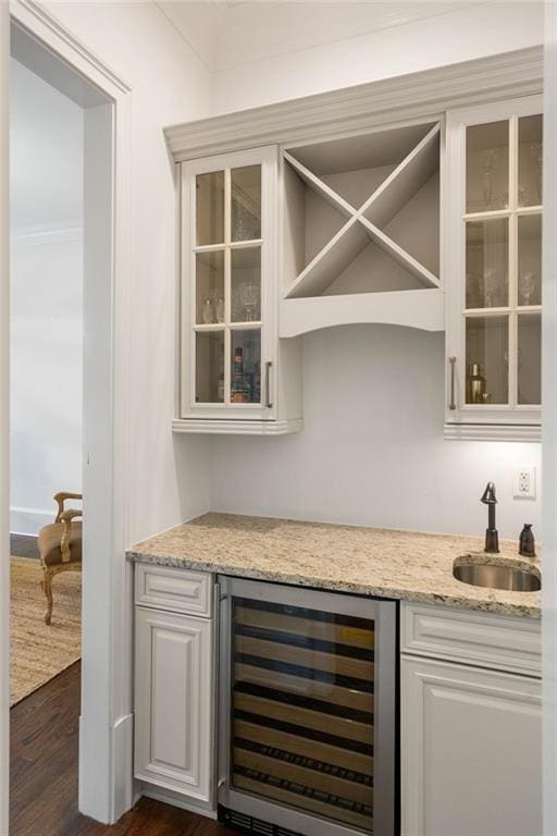 bar featuring white cabinets, sink, dark hardwood / wood-style floors, and beverage cooler